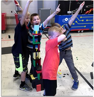 Students celebrating the creation of a tall tower.