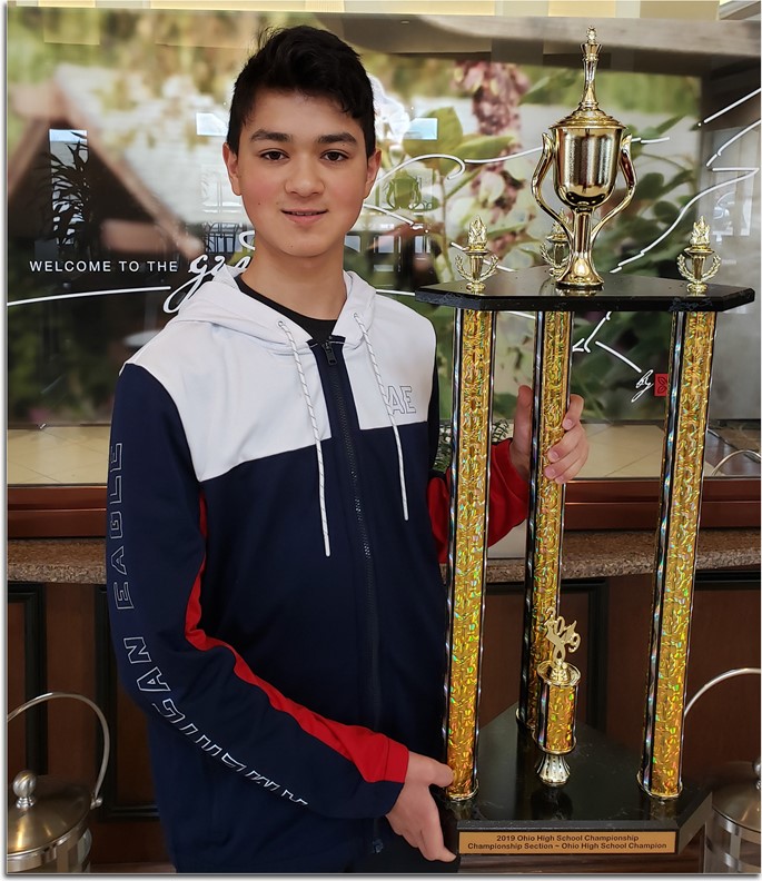 Jingwei Baker holding the State Chess Champion trophy.
