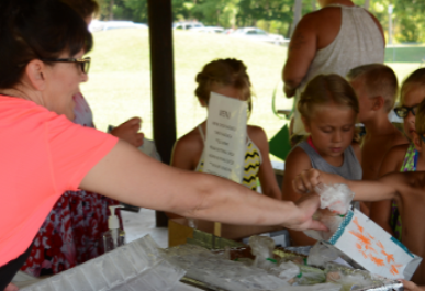 Food service employees serving summer lunch to students..