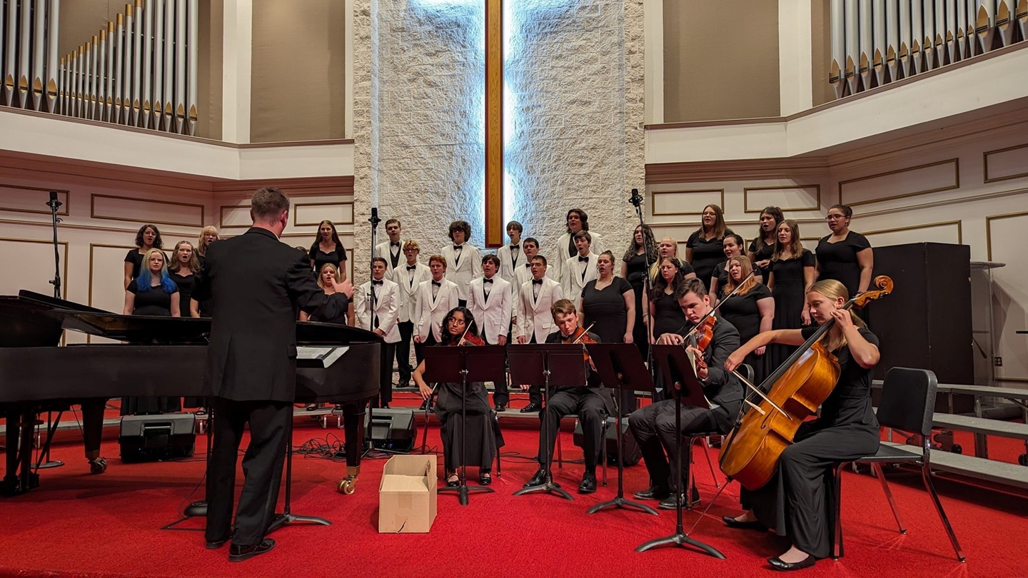 Trevor Garrabrant conducts the MVHS Chorale and String Quartet in performance.