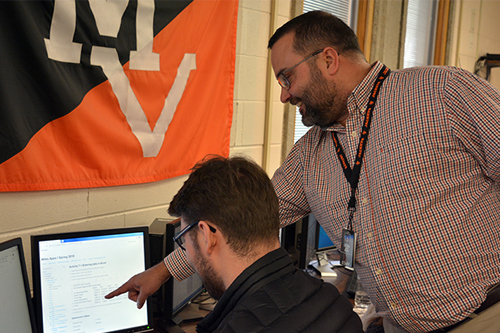 Student being instructed in computer science class.