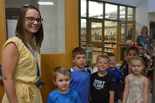 Teacher and students in the entrance to Twin Oak's office.