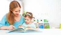 Mom reading a book with her daughter.