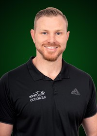 Portrait of Mr. Roberts in a black shirt with a green background