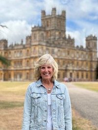 Mrs. Ward standing in front of Highclere Castle